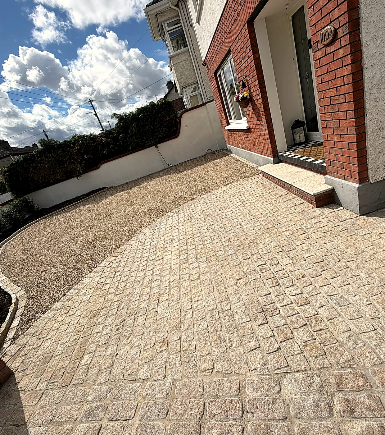 Granite cobble apron and gravel at the front door of the Churchtown house, with the rebuilt brick entrance pier