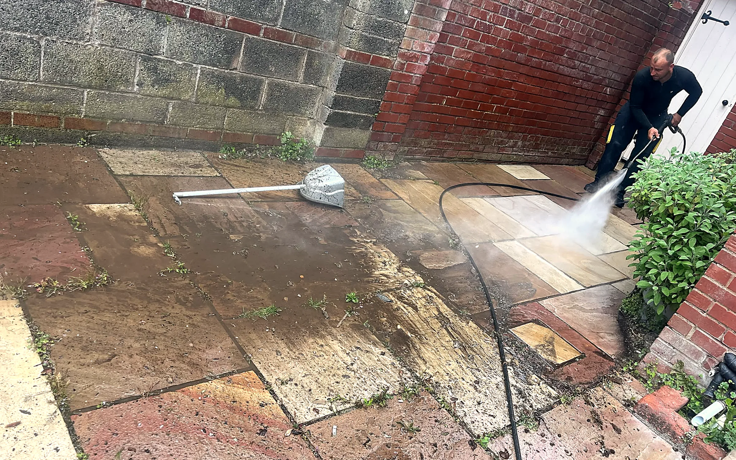 Sandstone patio being power-washed back to clean stone