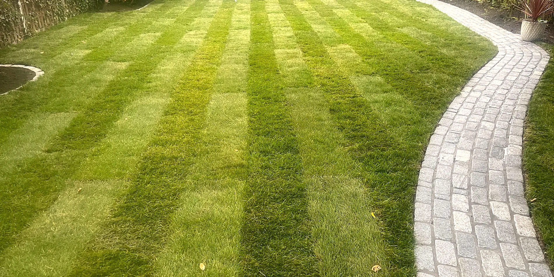 Granite cobble pathway curving through a new striped lawn, Bray