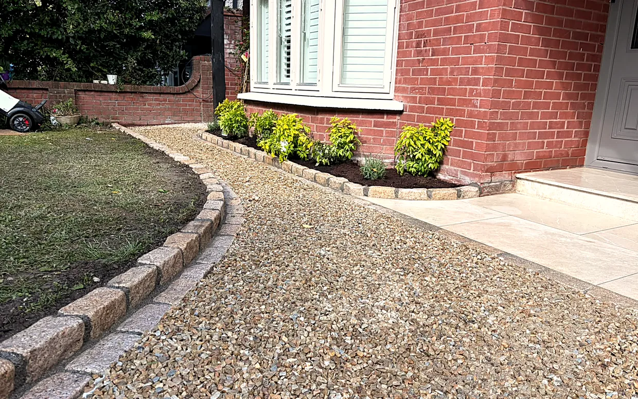 Angular gravel bedded over a compacted base and a weed membrane, raked to a level finish.