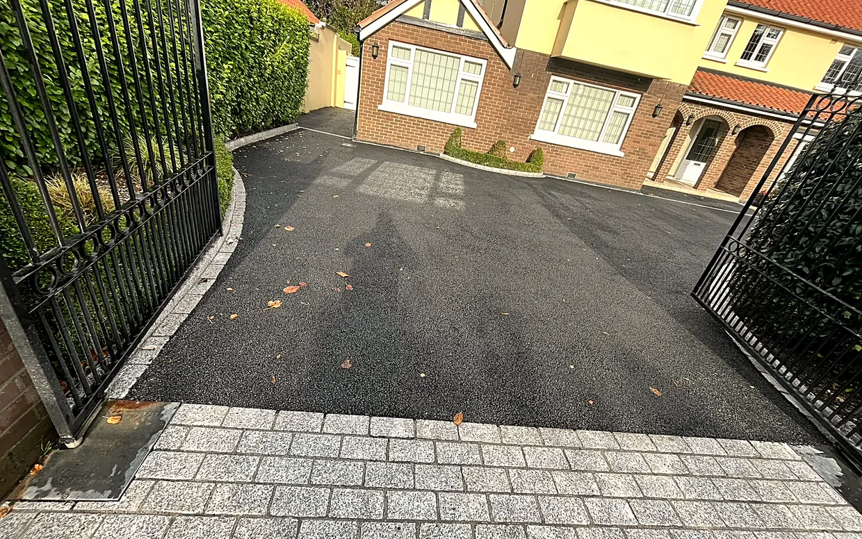 Granite edging set on concrete holds the tarmac edge so it does not creep or crack away.