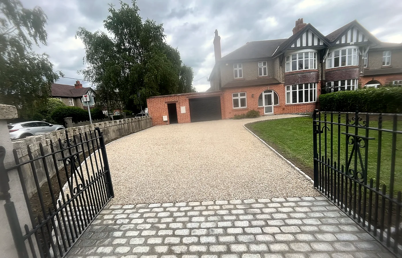 A cream gravel driveway with a silver granite cobble apron behind iron gates, South Dublin