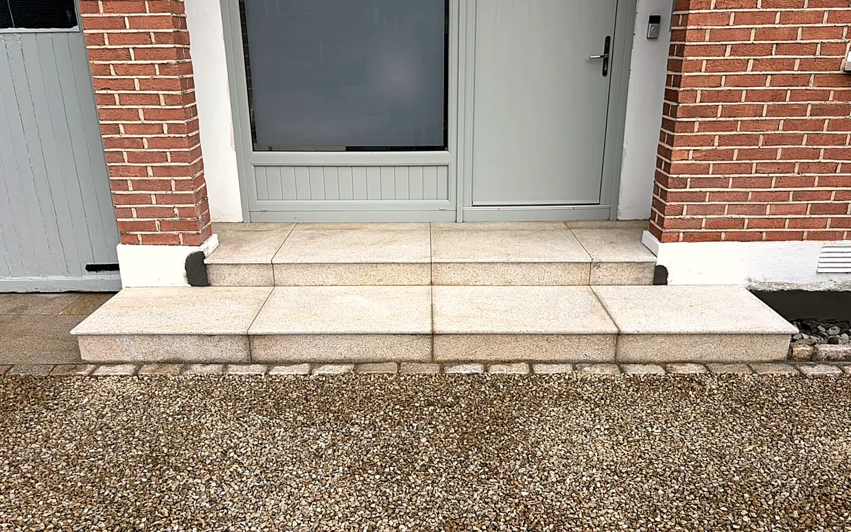 Granite steps and a cobble edge where a gravel driveway meets the front door: the kind of extra that adds to the cost and the finish.