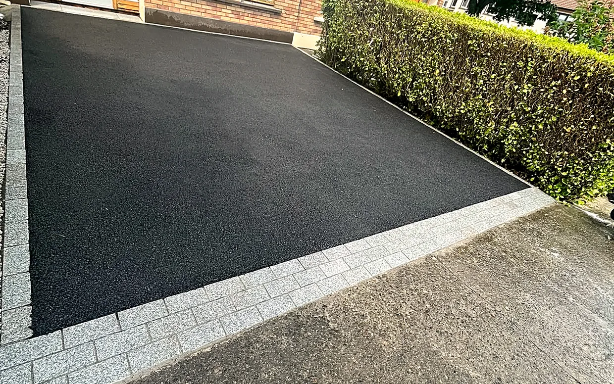 A dense driveway surface laid to falls over a compacted stone base.