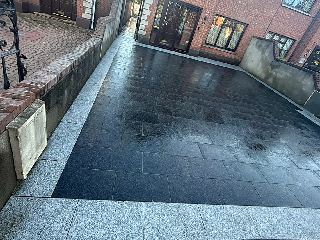 The new black granite driveway in Cabinteely from the gate, the silver granite border wrapping the raised bed