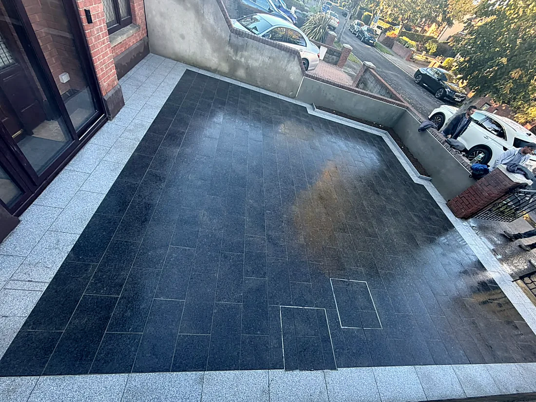The front driveway from above: black granite framed in silver granite, the bed beside the gate