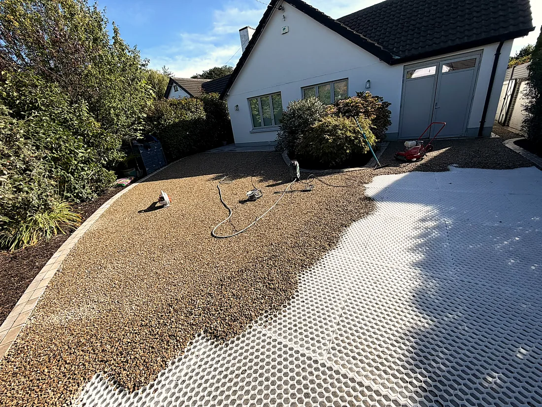 Mid-work: gravel being spread over the grid, the bed edged in cobbles