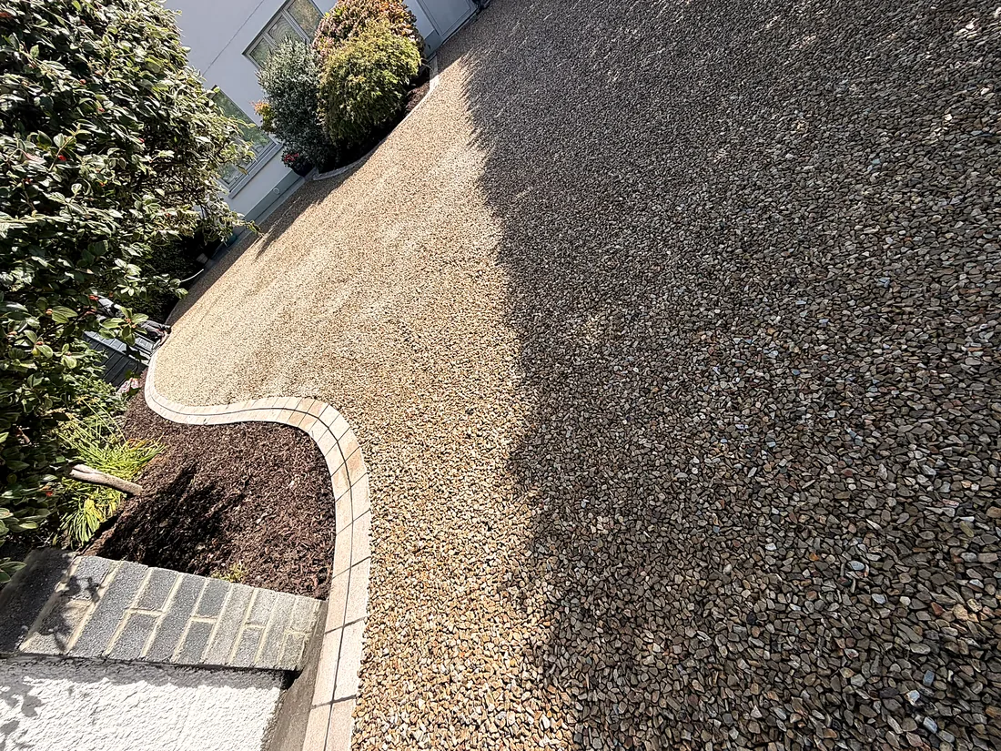 The Egyptian limestone cobble edge curving round the planted bed, gravel to one side