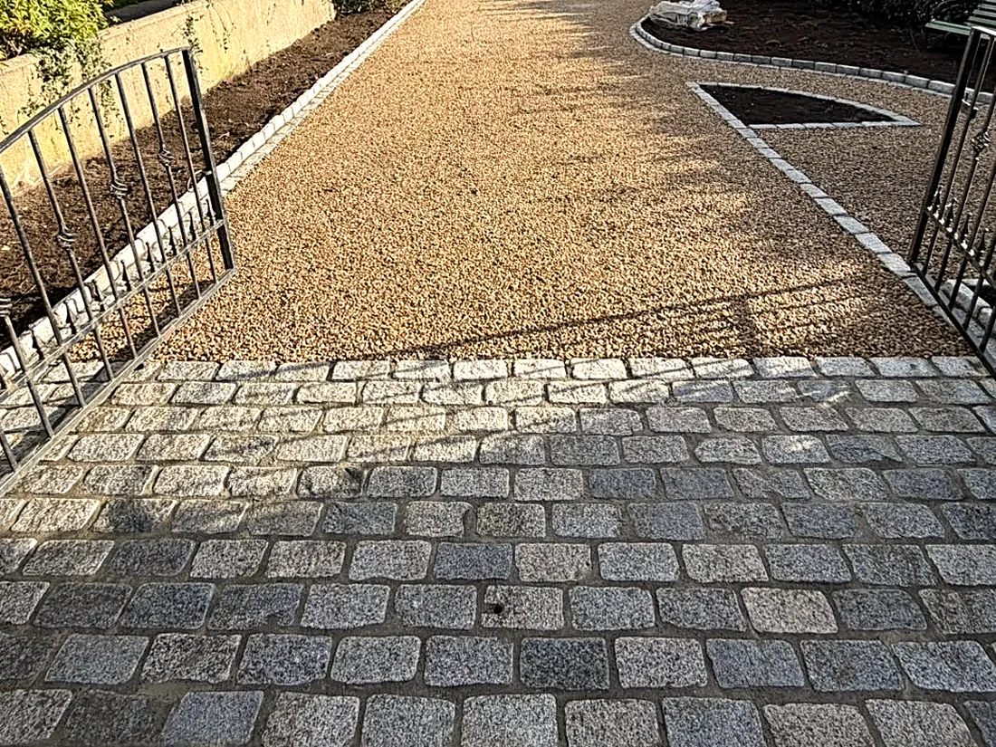 The gravel drive from the gate: the granite cobble apron, then gravel up to the house