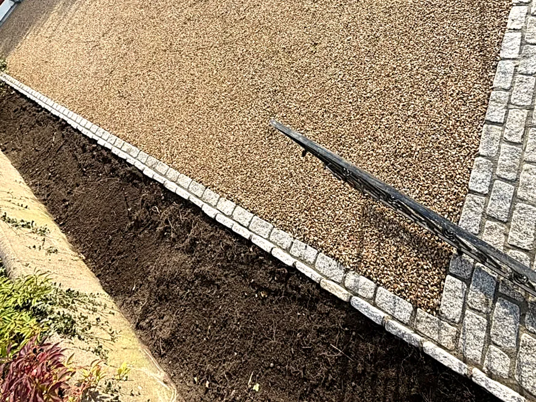 The gravel, the cobble apron and the granite-edged bed from the gate