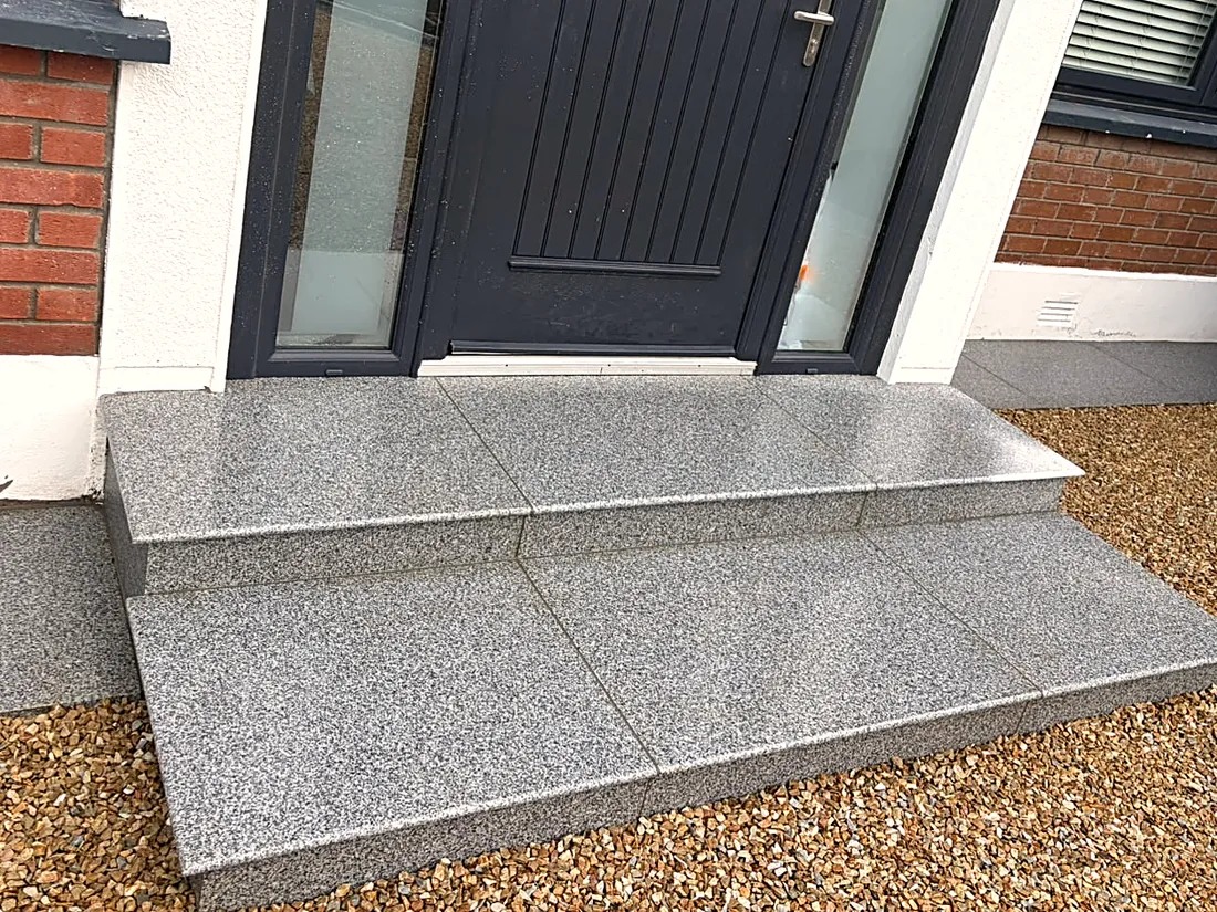 The new granite steps at the front door, gravel either side