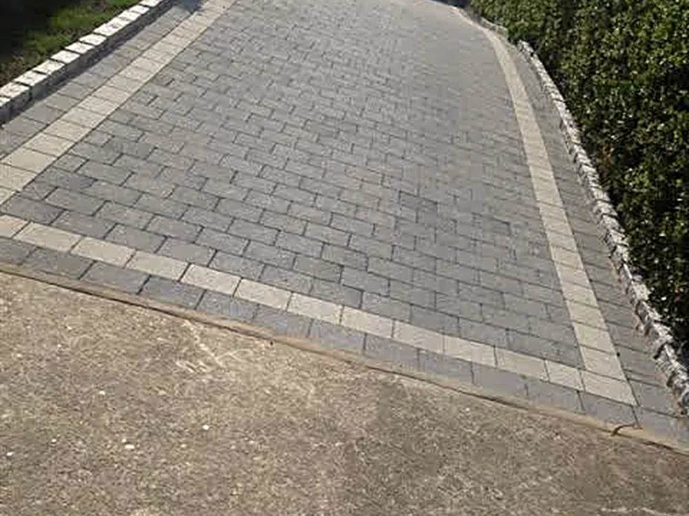 Grey block paving squared to a hedge line