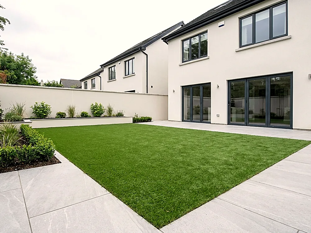 Level artificial lawn framed by porcelain paving