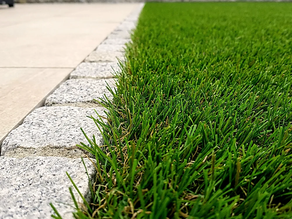 Artificial grass meeting a porcelain paved patio