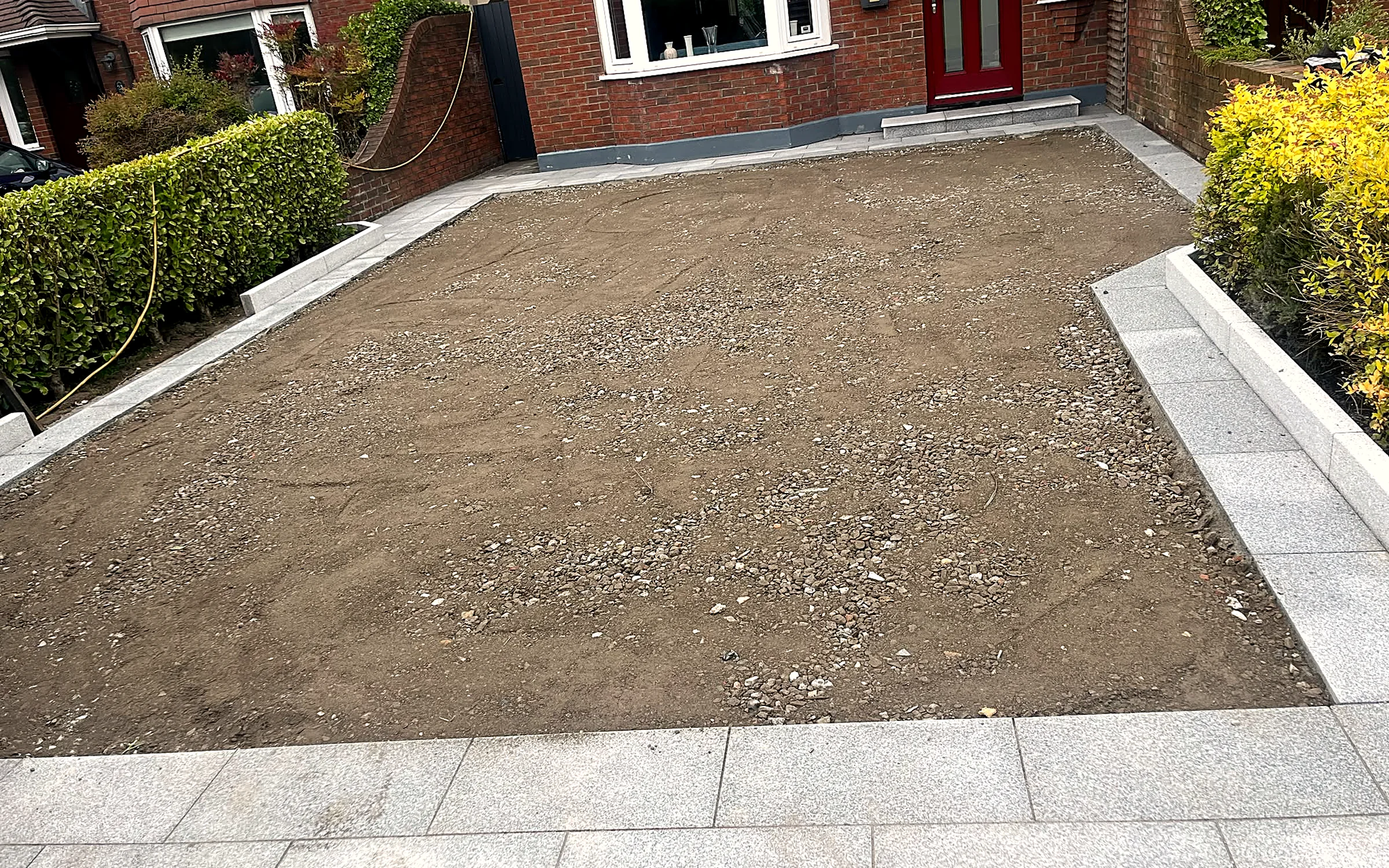 Driveway dig-out underway, with granite edging being set