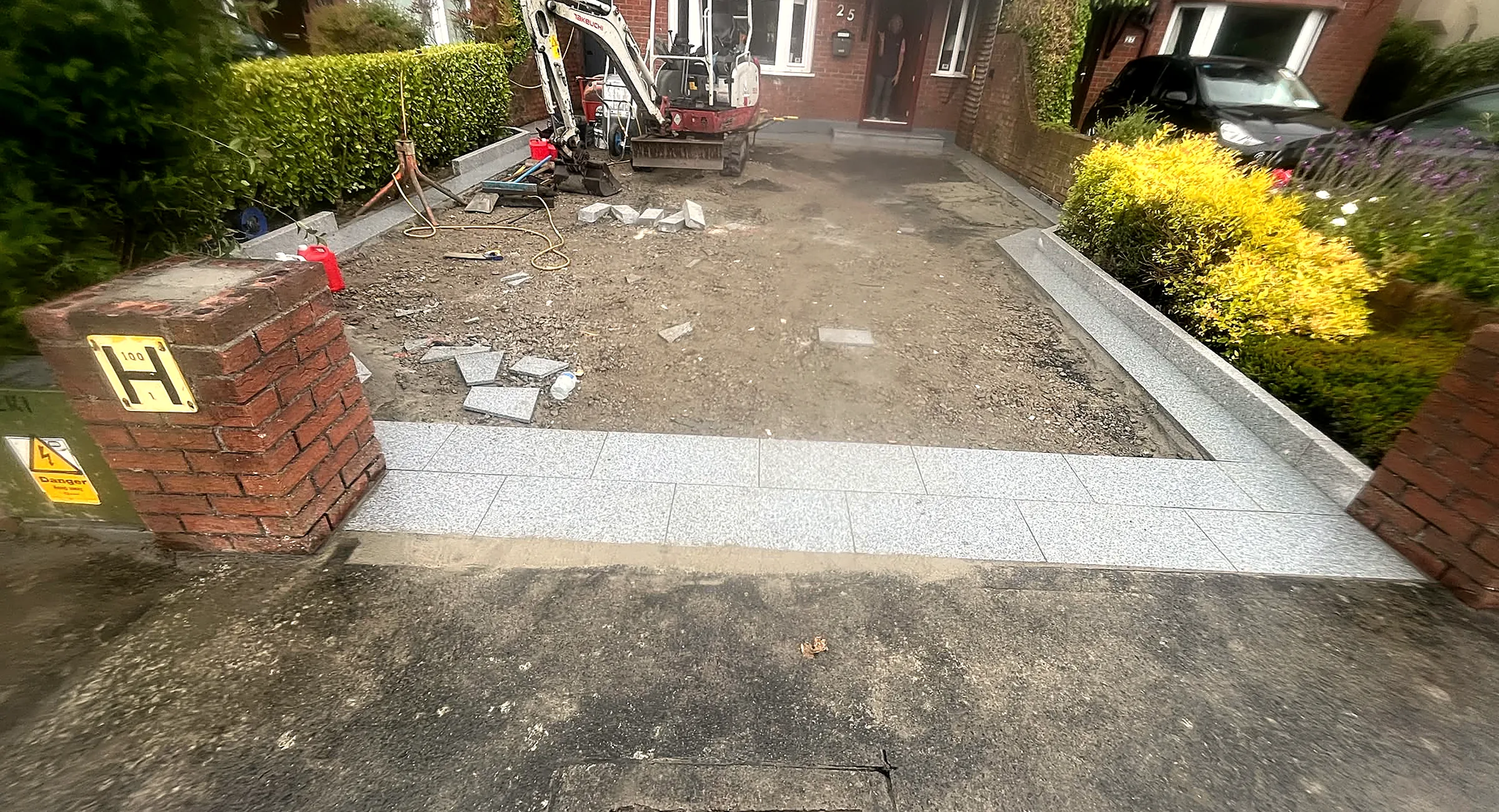 Driveway dig-out underway, with granite edging being set