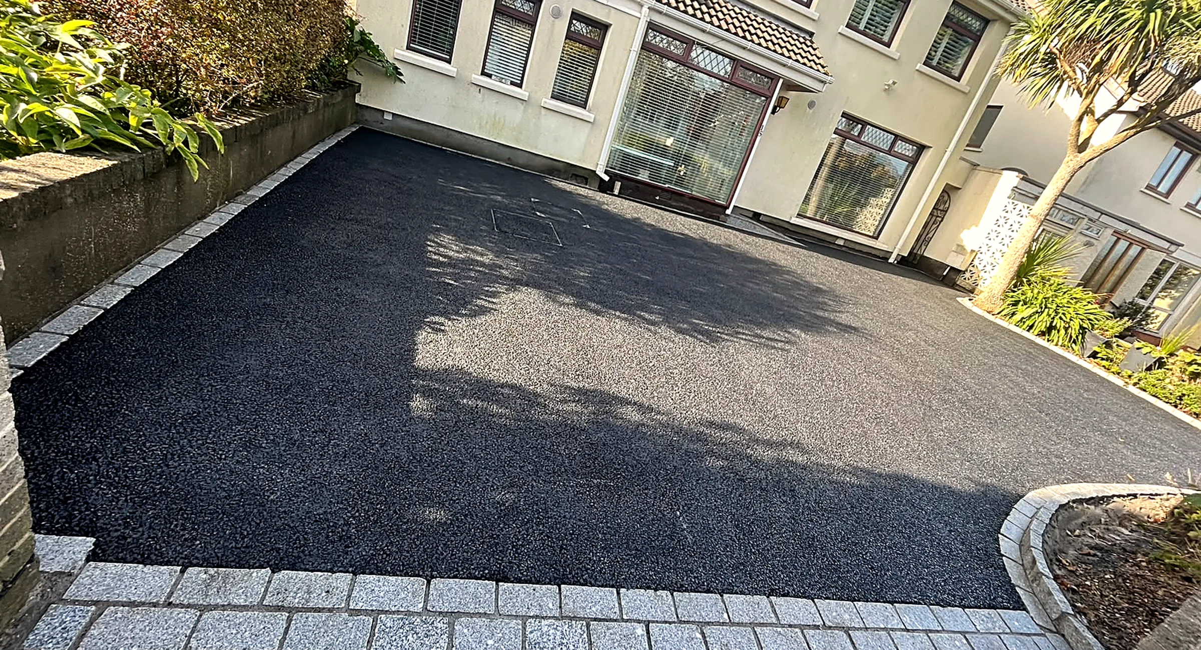 Machine-laid tarmac driveway with granite cobble apron